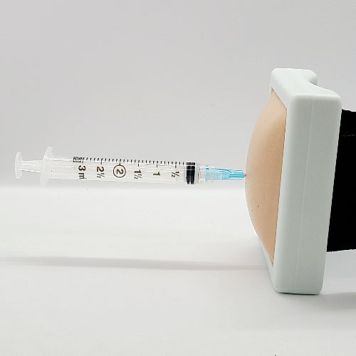 Syringe being inserted into a white block with a black interior on a light gray background