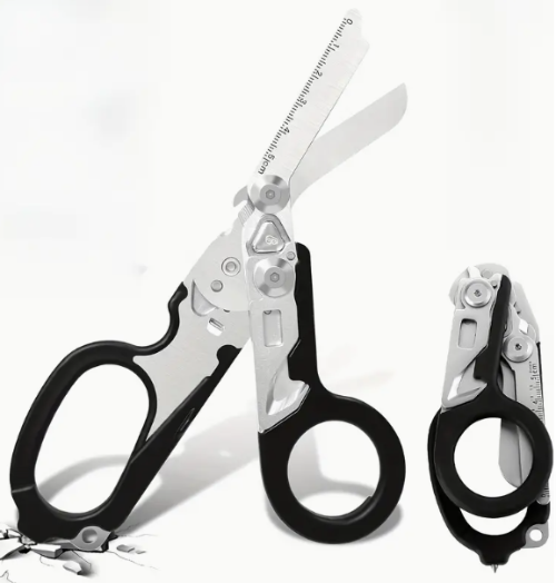 A pair of stainless steel trauma shears with a black handle, displayed alongside its opened case which reveals multiple tools such as a folding knife, ruler, and glass breaker.