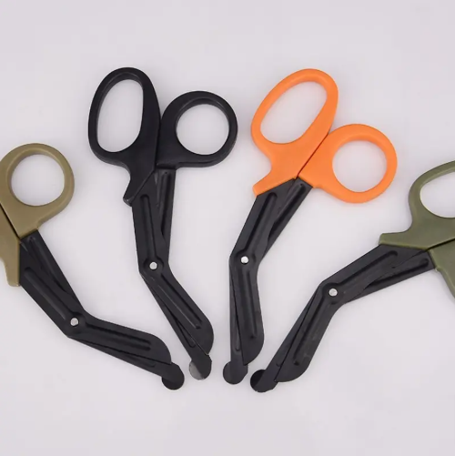 A collection of trauma shears in black, orange, and green colors, with straight blades and ergonomic handles.