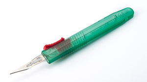 A single green and red disposable retractable safety scalpel with a blade.