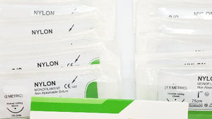 Packaging of surgical sutures with visible branding and text.