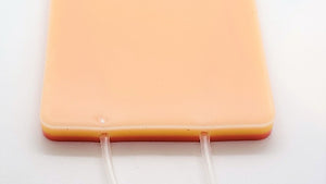 A beige venipuncture pad with a 3mL syringe and a 23G needle attached to the pad.